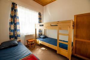 a bedroom with two bunk beds and a window at LÁSZLÓ Turistaszálló in Visegrád