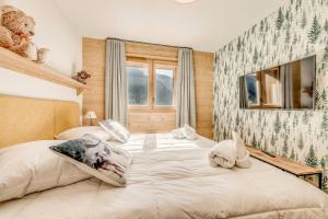 un grande letto bianco in una camera da letto con finestra di Résidence Les Nouveaux Alpages - Appartement très confortable avec accès SPA inclus MAE-8224 a Champagny-en-Vanoise Altre 22 foto