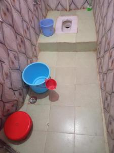 a bathroom with a toilet and a bucket and a sink at Badri Kedar Hometay in Joshīmath