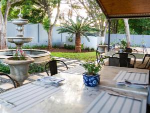 an outdoor table with a fountain and chairs at De Akker Guest House Louis Trichardt in Louis Trichardt