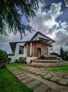 une maison avec un chemin en pierre devant elle dans l'établissement LaMansion Inn, à Cherrapunji