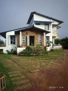 une maison avec une cour d'herbe devant elle dans l'établissement LaMansion Inn, à Cherrapunji