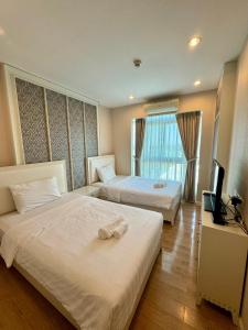 una camera d'albergo con due letti e una televisione di Harmony Resort Apartment Chiangmai a Chiang Mai