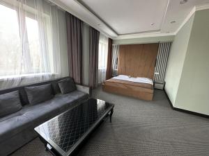 sala de estar con sofá y cama en Faeton en Almaty