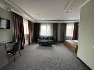 a hotel room with a bed and a couch at Faeton in Almaty