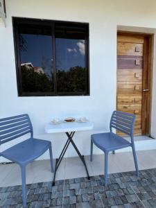 2 chaises bleues, une table et une fenêtre dans l'établissement Reinhardshausen Suites and Residences- Lovely Air-Conditioned Units, à Tuguegarao