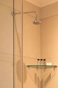 um chuveiro com duas garrafas numa prateleira de vidro em Protea Hotel by Marriott Franschhoek em Franschhoek