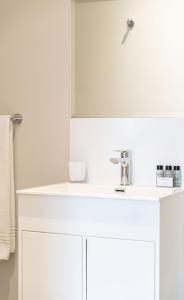 Baño blanco con lavabo y espejo en Protea Hotel by Marriott Franschhoek, en Franschhoek