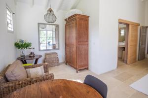 ein Wohnzimmer mit einem Tisch und einem Holzschrank in der Unterkunft Villa Saint Alban by Habitation Saint Charles in Petit-Bourg