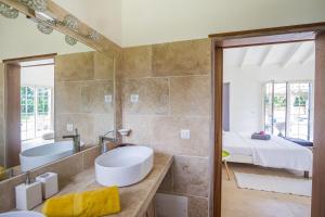 a bathroom with a sink and a mirror and a bed at Villa Saint Alban by Habitation Saint Charles in Petit-Bourg