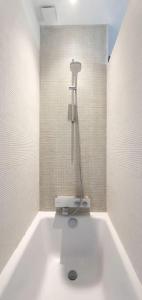 La salle de bains est pourvue d'une douche et d'une baignoire blanche. dans l'établissement Maison de Ville Ty Art, à Quiberon
