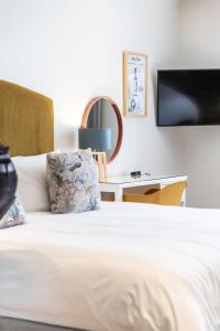 a bedroom with a bed with a tv on the wall at Protea Hotel by Marriott Franschhoek in Franschhoek