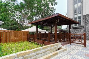 a wooden gazebo in front of a building at Hoya Hot Springs Resort, Guanziling in Baihe