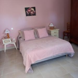 a bedroom with a large bed with pink sheets and pillows at Boufavent in Salettes