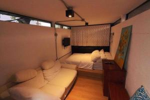 um quarto com um sofá e uma cama em TinyHouse w/ Pool & Alfresco Area for Guests em Bacolod