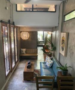 uma sala de estar com um sofá azul e uma mesa em TinyHouse w/ Pool & Alfresco Area for Guests em Bacolod