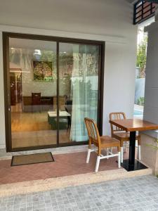 een tafel en een stoel en een tafel en een kamer bij Aonang Peace Pool Villa in Ban Khlong Haeng