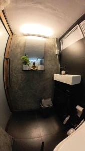 uma casa de banho com um lavatório e uma pessoa num espelho em TinyHouse w/ Pool & Alfresco Area for Guests em Bacolod