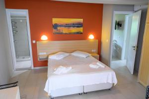 1 dormitorio con 1 cama con 2 toallas en Rouda Bay Beach Hotel, en Mikros Gialos