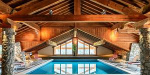 an indoor pool in a house with wooden ceilings at Résidence Les Nouveaux Alpages - 5 Pièces pour 8 Personnes 664 in Champagny-en-Vanoise