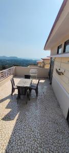 a patio with a table and a bench on a balcony at Siddhi Sea View Bungalow Ganpatipule in Ratnagiri
