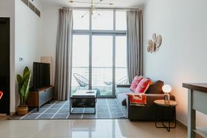 ein Wohnzimmer mit einem Sofa und einem TV in der Unterkunft Cozy 1 BR in Dubai Marina in Dubai