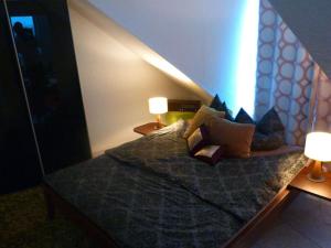 een slaapkamer met een bed met kussens en 2 lampen bij Holiday apartment Wedel in Augsburg