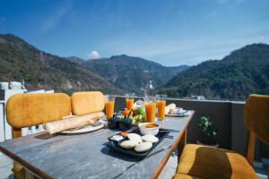 a table with food on top of a balcony with mountains at Tripli Hotels Ayushman Retreat in Rishīkesh