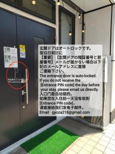 um sinal é colocado na lateral de um edifício em セルフチェックイン Guest House SHUKUGO UTSUNOMIYA em Utsunomiya