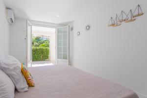- une chambre blanche avec un lit et une porte ouverte dans l'établissement Beau 40m² Proche du centre Wifi, à Saint-Raphaël