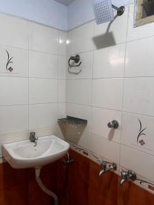 a white bathroom with a sink and a mirror at MOA Auroville pondicherry in Auroville