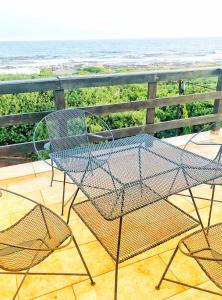 uma mesa e cadeiras numa varanda com o oceano em Nautical @ Salt Shore Studios em Hermanus