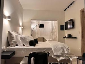 - une chambre dotée d'un grand lit avec des draps et des oreillers blancs dans l'établissement Perla Coco Jacuzzi Suites, à La Canée