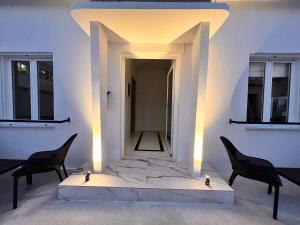 biały pokój z 2 krzesłami i korytarzem w obiekcie Perla Coco Jacuzzi Suites w Chanii