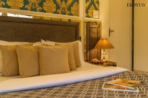 a bed with pillows and a table with a lamp at Ekostay Gold - Olive Crest Villa - Spacious Lawn in Lonavala