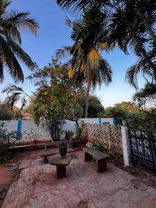 a picnic table and bench in front of a fence at MOA Auroville pondicherry in Auroville