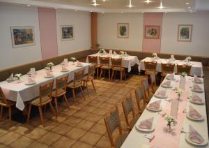 una sala da pranzo con tavoli e sedie con fiori di Gasthof-Pension Fränkische Schweiz Obertrubach a Obertrubach
