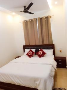 a bedroom with a white bed with red pillows at P Villa in Devanahalli-Bangalore
