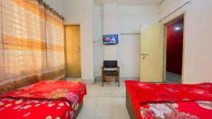 a hospital room with a red bed and a chair at Hotel Al Makka in Dhaka