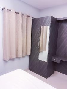 a bathroom with a mirror and curtains in a room at P Villa in Devanahalli-Bangalore