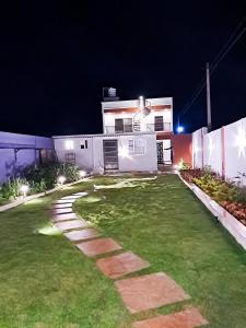 a yard with a house at night with lights at P Villa in Devanahalli-Bangalore