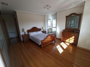 a bedroom with a bed and a dresser and a mirror at Ca' Truyés in El Pino