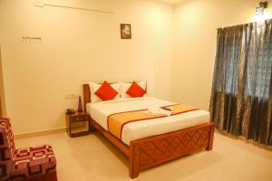 a bedroom with a bed and a window at FabHotel Home Tree Service Apartment Kolathur in Chennai
