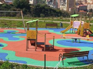 a park with a playground with a slide and benches at Ca' Truyés in El Pino