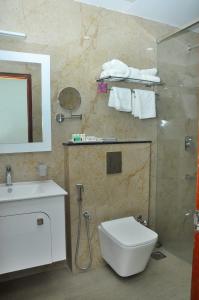 a bathroom with a toilet and a sink and a mirror at Kallada Mamatha Motels in Kunnamkulam