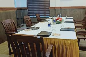 a large table with chairs in a room at Kallada Mamatha Motels in Kunnamkulam