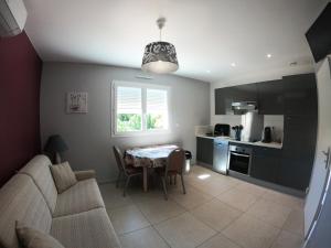 a kitchen and living room with a table and a couch at Gite ARCADIA in Saint-Ambroix