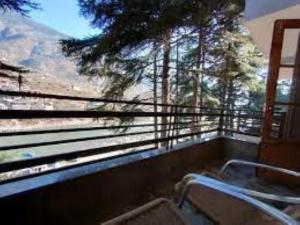 a balcony with a chair and a view of a mountain at Hotel Saryal , Kullu in Kulu