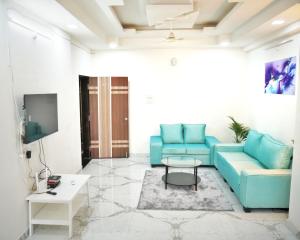 sala de estar con sofá azul y mesa en Hyderabad Home: Serene 3BHK Retreat in the Heart of the City, en Hyderabad