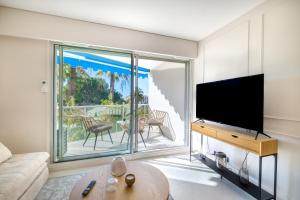 a living room with a flat screen tv and a large window at Appartement Le Montfleury in Cannes